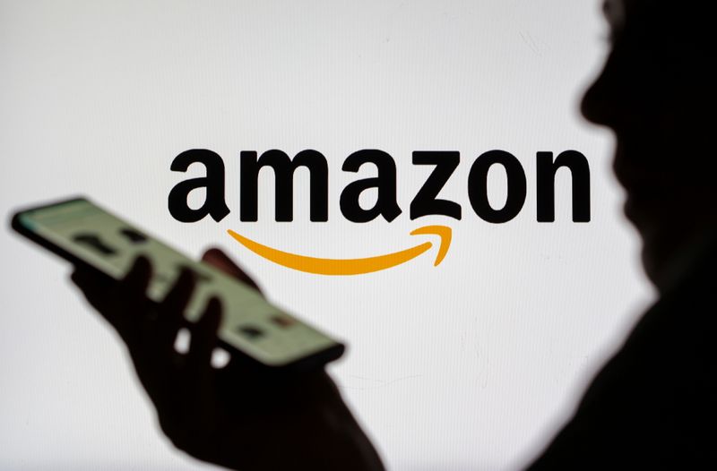 &copy; Reuters. FILE PHOTO: Woman with smartphone is seen in front of displayed Amazon logo in this illustration taken, July 30, 2021. REUTERS/Dado Ruvic/Illustration