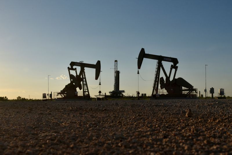 &copy; Reuters. FILE PHOTO: Pump jacks operate in front of a drilling rig in an oil field in Midland, Texas U.S. August 22, 2018. REUTERS/Nick Oxford