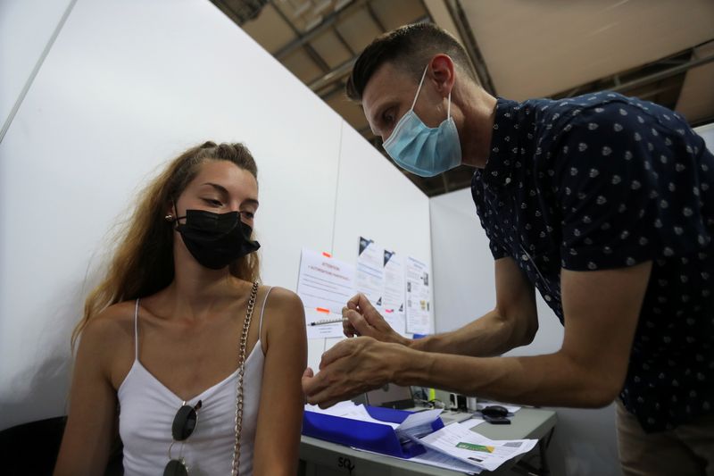 &copy; Reuters. Profissional de saúde aplica vacina contra Covid-19 em mulher em centro de vacinação a sudoeste de Paris
13/08/2021 REUTERS/Sarah Meyssonnier
