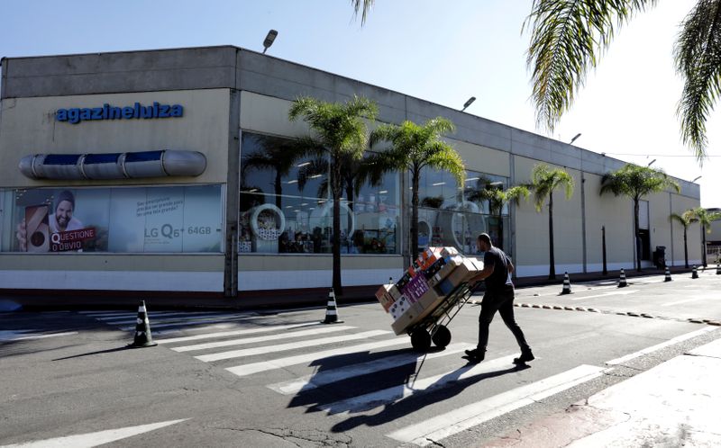 &copy; Reuters. Homem transporta produtos na frente de lojas do Magazine Luiza. 21/4/2018.  REUTERS/Paulo Whitaker 