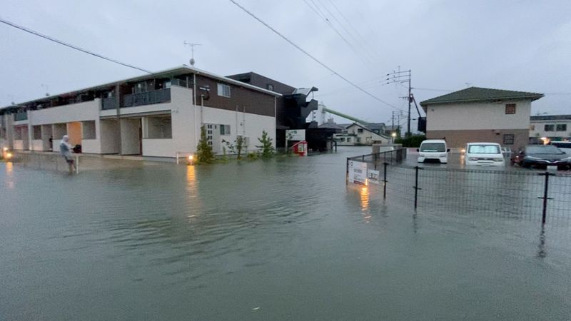 © Reuters. A person stands at a flooded street during heavy rain in Kurume, Fukuoka Prefecture, Japan August 14, 2021, in this still image taken from video provided on social media. Mandatory credit TWITTER @NAPSPANS/via REUTERS  