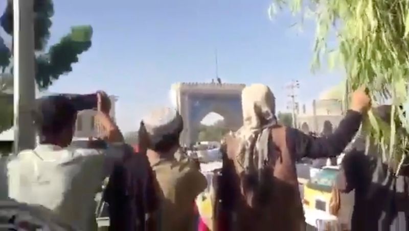 &copy; Reuters. Fotograma de una grabación de vido subida a redes sociales que muestra a personas reunidas mientras los talibanes ondean su bandera en la entrada de Kandahar, Afganistán. 14 agosto 2021. Entregada por los talibanes/vía Reuters. ESTA IMAGEN FUE ENTREGAD