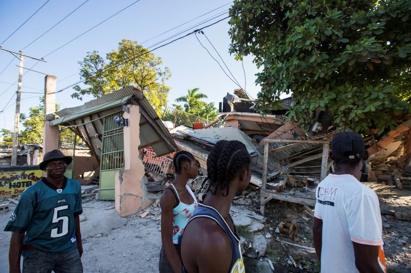 &copy; Reuters. People walk past a house destroyed following a 7.2 magnitude earthquake in Les Cayes, Haiti August 14, 2021. REUTERS/Ralph Tedy Erol  