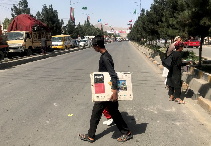 © Reuters. رجل يعبر الطريق في كابول يوم الأحد. تصوير:رويترز.
