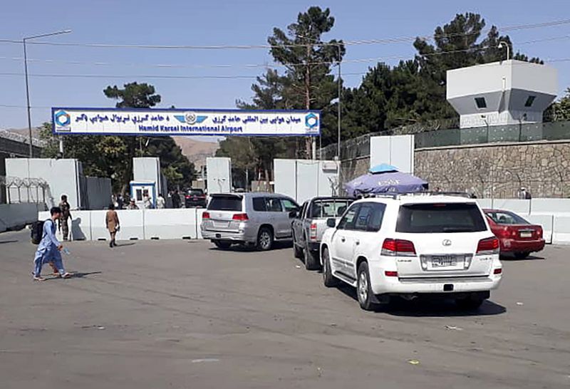 © Reuters. الشرطة الأفغانية تفتش السيارات عند بوابة دخول مطار حامد كرزاي الدولي في كابول يوم الأحد - رويترز