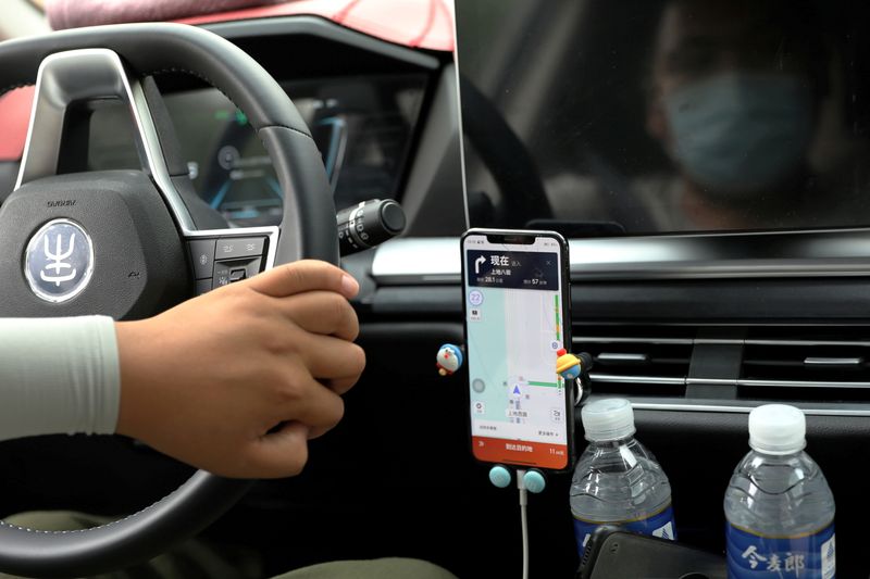 &copy; Reuters. FILE PHOTO: A driver of Chinese ride-hailing service Didi drives with a phone showing a navigation map on Didi's app, in Beijing, China July 5, 2021. REUTERS/Tingshu Wang/File Photo