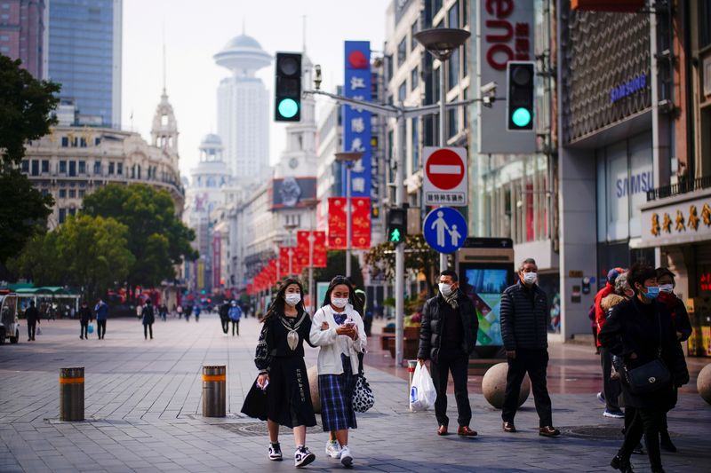 &copy; Reuters. FILE PHOTO: People wearing face masks walk at a main shopping area, following the coronavirus disease (COVID-19) outbreak in Shanghai, China January 27, 2021. REUTERS/Aly Song/File Photo