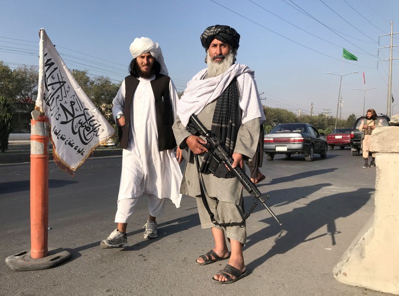 &copy; Reuters. مقاتلان من طالبان يقفان أمام مقر وزارة الداخلية في كابول يوم الاثنين. صورة لرويترز.
