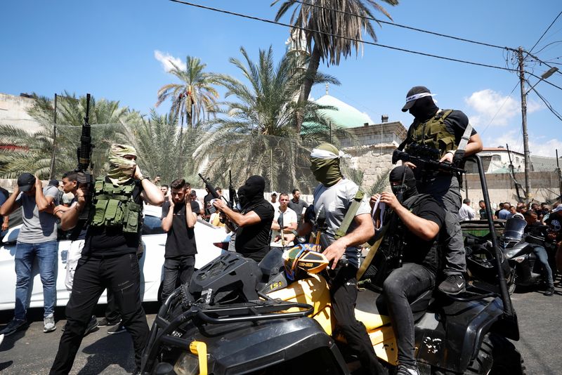 © Reuters. مسلحون يحضرون جنازة فلسطينيين قتلا مع آخرين خلال مداهمة للقوات الإسرائيلية في مدينة جنين بالضفة الغربية المحتلة يوم الاثنين. تصوير: محمد تركمان - رويترز.
