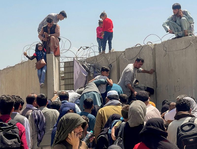 &copy; Reuters. أشخاص يحاولون دخول مطار حامد كرزاي الدولي في كابول يوم الاثنين. صورة لرويترز. يحظر إعادة بيع الصورة أو الاحتفاظ بها في أرشيف.