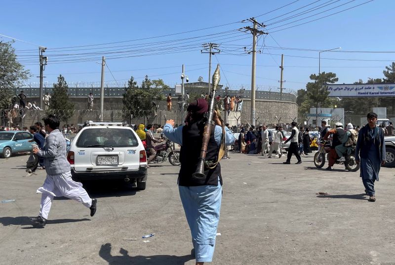 © Reuters. مقاتل من طالبان خارج مطار حامد كرزاي الدولي في كابول يوم الاثنين. صورة لرويترز تحظر إعادة بيعها أو حفظها في أرشيف.