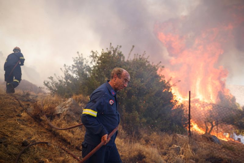 &copy; Reuters. Bomberos tratan de extinguir un incendio forestal que arrasa con la aldea de Markati, cerca de Atenas. Agosto 16, 2021. REUTERS/Alkis Konstantinidis