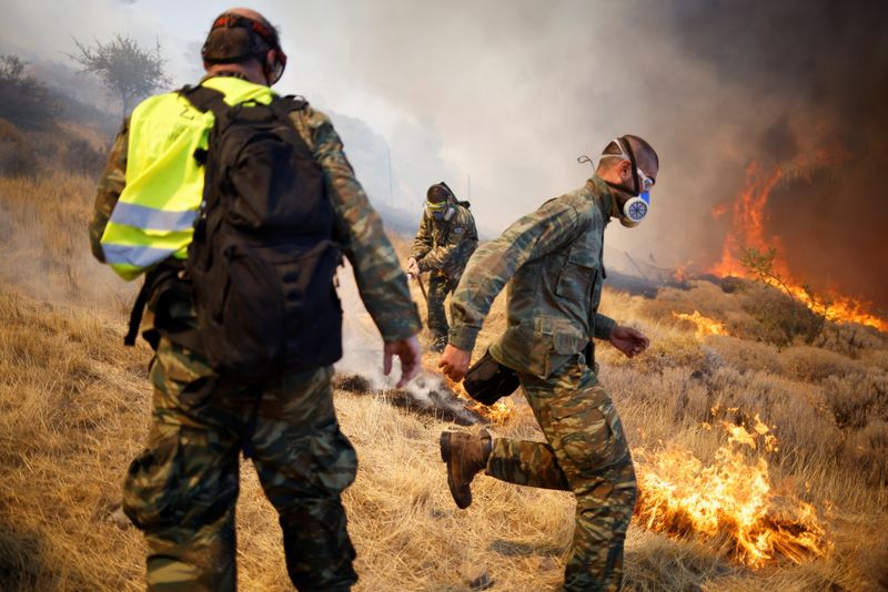 &copy; Reuters. متطوعون يحاولون إخماد حريق غابات بالقرب من أثينا يوم الاثنين. تصوير: الكيس قنسطنطنيدس - رويترز.