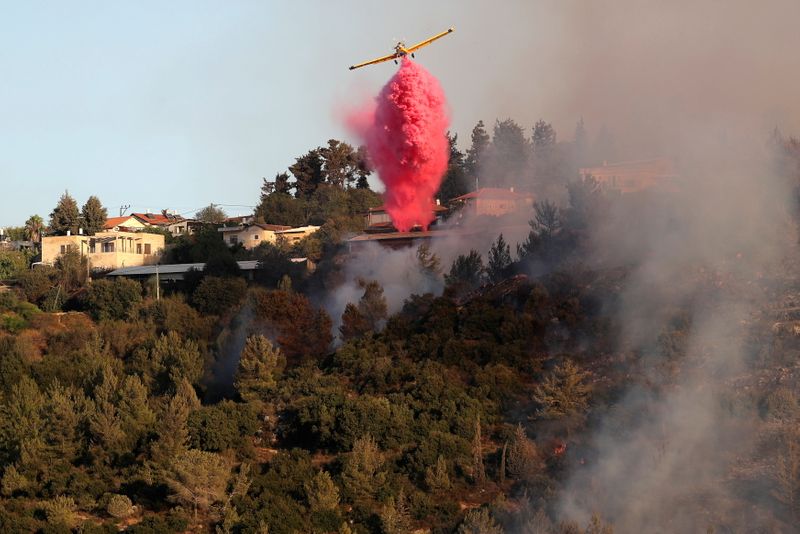 &copy; Reuters. Les pompiers israéliens luttant depuis dimanche contre un incendie dans des collines boisées près de Jérusalem ont évacué lundi de nouvelles communautés. /Photo prise le 16 août 2021/REUTERS/Ammar Awad