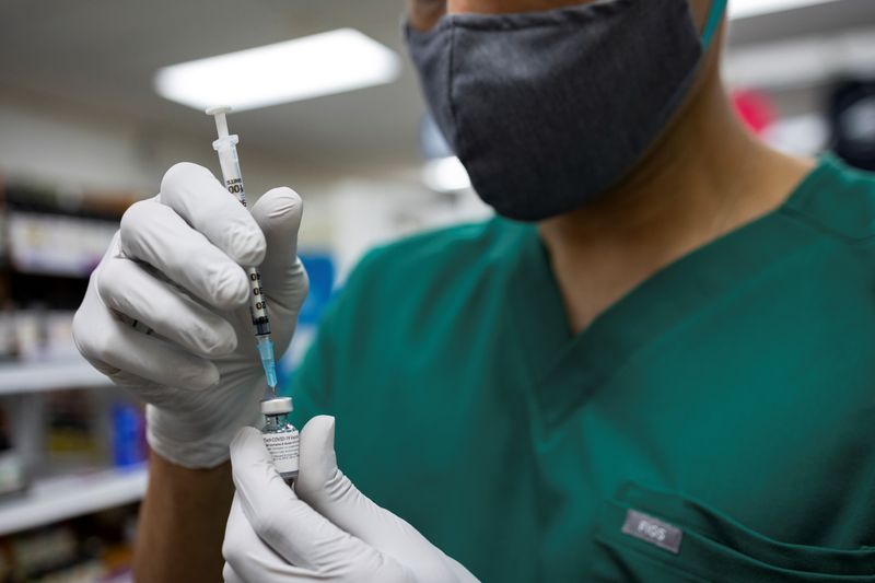 &copy; Reuters. FILE PHOTO: Dr. Mayank Amin draws a dose of the Pfizer-BioNTech coronavirus disease (COVID-19) vaccine before giving a booster dose at Skippack Pharmacy in Schwenksville, Pennsylvania, U.S., August 14, 2021.  REUTERS/Hannah Beier