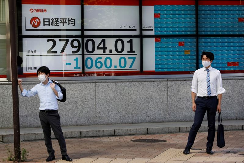 &copy; Reuters. رجلان يقفان أمام شاشة إلكترونية تعرض مؤشر نيكي أمام مكتب للسمسرة في طوكيو يوم 21 يونيو حزيران 2021. تصوير: كيم كيونج-هوون - رويترز.