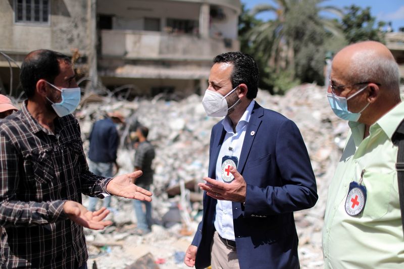 © Reuters. روبرت مارديني المدير العام للجنة الدولية للصليب الأحمر يتحدث مع رجل فلسطيني أثناء تفقد منزل دمرته ضربة جوية إسرائيلية في مدينة غزة يوم 2 يونيو حزيران 2021. تصوير: محمد سالم - رويترز.