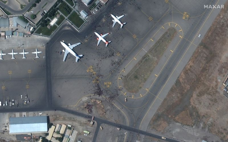 &copy; Reuters. FILE PHOTO: Crowds of people are seen on the tarmac at Kabul's airport in Afghanistan August 16, 2021. SATELLITE IMAGE 2021 MAXAR TECHNOLOGIES/Handout via REUTERS. 