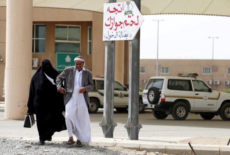 © Reuters. رجل يمني يسير مع زوجته لدى وصولهما لختم جواز السفر للدخول إلى السعودية في جازان بصورة من أرشيف رويترز.