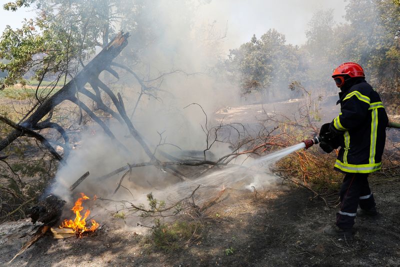 &copy; Reuters. Un bombero extingue un incendio que comenzó en Cogolin en la región de Var, en el sur de Francia. 17 de agosto, 2021. REUTERS/Eric Gaillard