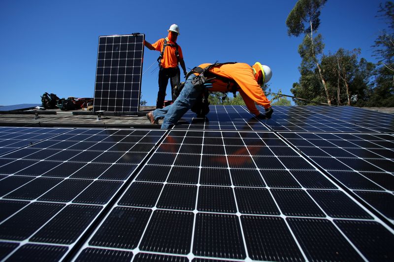 © Reuters. فنيون يركبون ألواحا شمسية في كاليفورنيا . رويترز