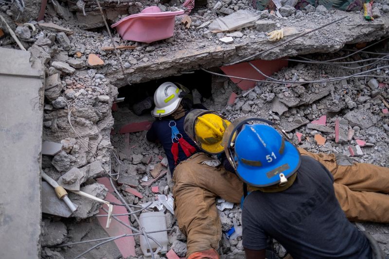&copy; Reuters. Bomberos haitianos buscan sobrevivientes bajo los escombros de un hotel destruido después del terremoto del sábado de magnitud 7,2, en Les Cayes, Haití. 16 de agosto, 2021. REUTERS/Ricardo Arduengo