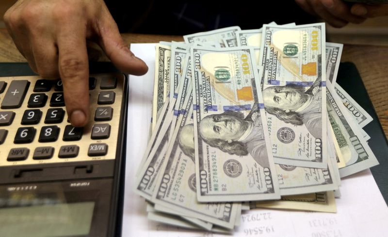 &copy; Reuters. FOTO DE ARCHIVO: Un empleado cuenta billetes de dólares estadounidenses en una casa de cambio en el centro de El Cairo, Egipto.