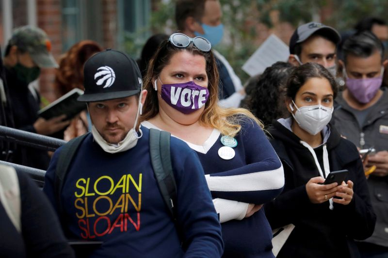 &copy; Reuters. FILE PHOTO: Voters wait in line for hours, including some who received sandwiches from volunteers in Brooklyn, to cast their ballots during early voting in the Brooklyn borough of New York City, New York, U.S., October 27, 2020. REUTERS/Mike Segar/File Ph