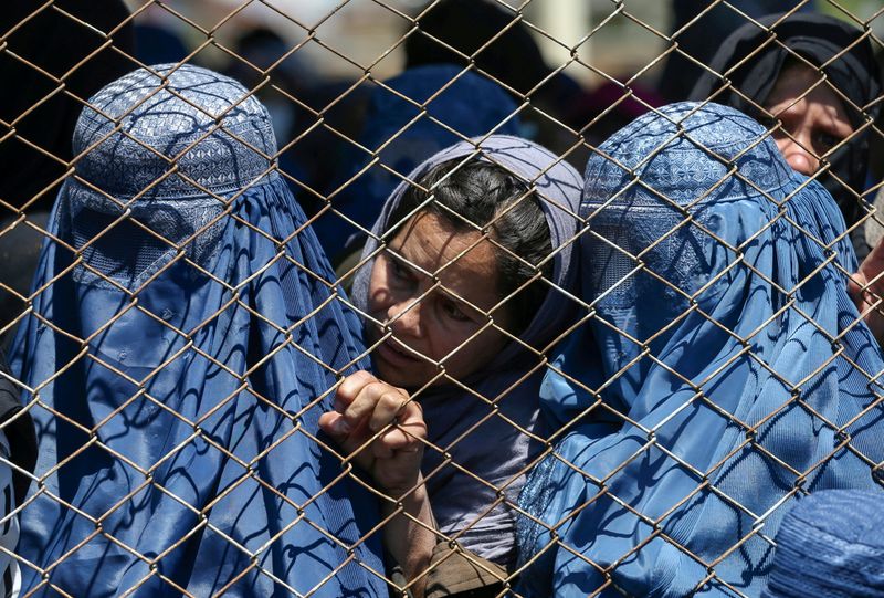 &copy; Reuters. FILE PHOTO: Afghan women wait to receive free wheat donated by the Afghan government during a quarantine, amid concerns about the coronavirus disease (COVID-19) in Kabul, Afghanistan April 21, 2020. REUTERS/Stringer