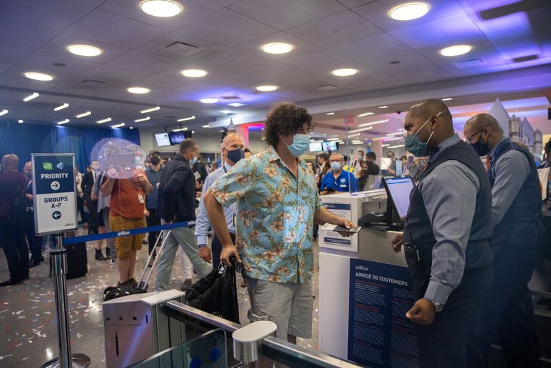 &copy; Reuters. FOTO DE ARCHIVO-Un pasajero muestra su pasaporte antes de un vuelo de JetBlue a Londres en el aeropuerto internacional JFK en el barrio de Queens de Nueva York, Nueva York, Estados Unidos. 11 de agosto de 2021. REUTERS/Jeenah Moon