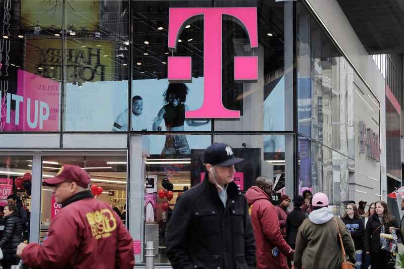 &copy; Reuters. Pedestrians walk past a T-Mobile store in New York, U.S., April 27, 2018. REUTERS/Lucas Jackson
