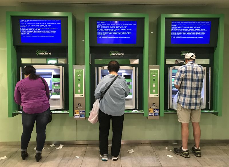 &copy; Reuters. FILE PHOTO: Customers use Toronto Dominion (TD) Bank ATM cash machines under video information screens showing a computer error in Toronto, Ontario, Canada June 24, 2017.  REUTERS/Chris Helgren