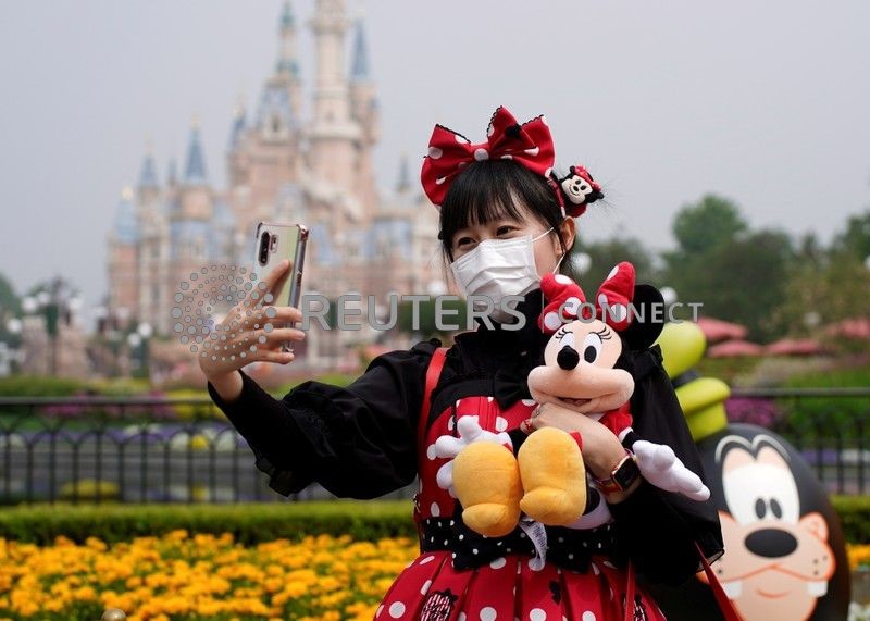 &copy; Reuters. Visitante de parque da Disney tira selfie usando máscara de proteção.
11/5/2020
REUTERS/Aly Song