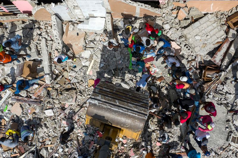 &copy; Reuters. أعمال البحث والإنقاذ وسط أنقاض خلفها الزلزال في مدينة لي كاي بهايتي يوم الأربعاء. تصوير: ريكاردو أرديونجو - رويترز. 