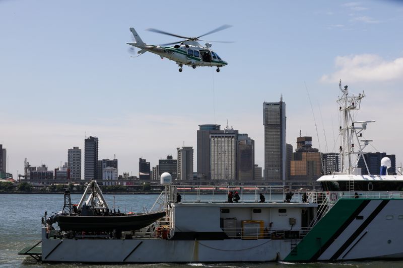 &copy; Reuters. 喧騒に満ちたナイジェリアのアパパ港。巡視船の上空をヘリコプターがホバリングし、戦闘艇がうなりを上げて通過する。ドックではナイジェリア国旗をペイントしたドローンが出動を待っ