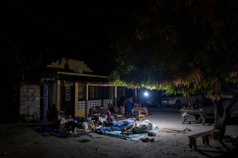 © Reuters. People rest outside their home after tremors shook buildings, following Saturday's 7.2 magnitude earthquake in Les Cayes, Haiti August 19, 2021. REUTERS/Ricardo Arduengo