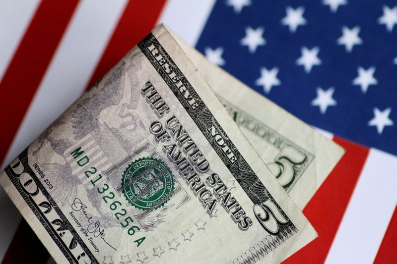 &copy; Reuters. Una banconota da 5 dollari statunitensi su una bandiera Usa.     REUTERS/Thomas White
