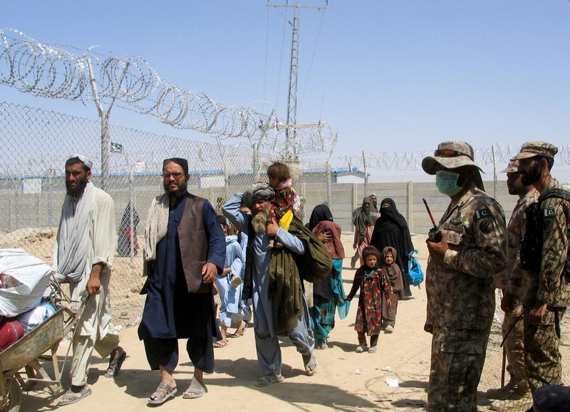 © Reuters. أفغان يدخلون باكستان من خلال معبر حدودي يوم الخميس. تصوير: سعيد علي - رويترز. 