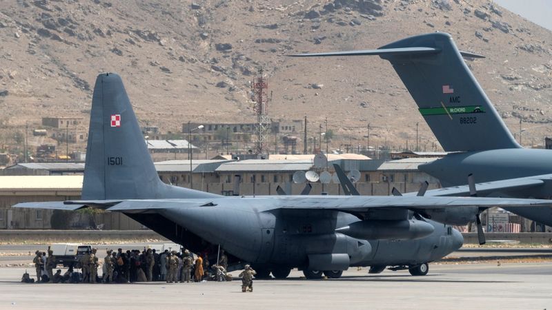 &copy; Reuters. أفراد من وزارة الدفاع الأمريكية يحرسون طائرة في مطار حامد كرزاي الدولي بكابول يوم 17 أغسطس آب - صورة حصلت عليها رويترز من طرف ثالث.
