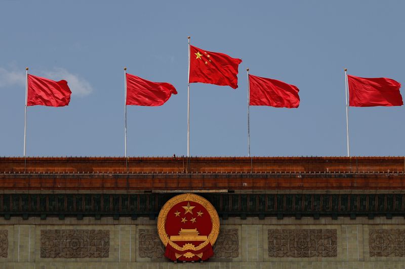 &copy; Reuters. FILE PHOTO: A Chinese flag flutters above the Chinese national emblem at the Great Hall of the People after the opening session of the National People's Congress (NPC) in Beijing, China May 22, 2020. REUTERS/Carlos Garcia Rawlins