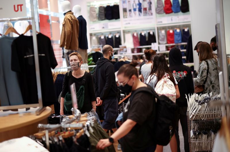 © Reuters. FOTO DE ARCHIVO: Personas con mascarillas compran dentro de una tienda de ropa en Londres, Reino Unido, el 26 de julio de 2021. REUTERS/Henry Nicholls