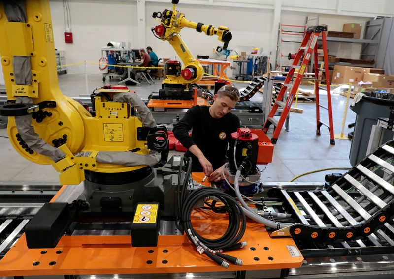 © Reuters. Robot technician Tyrus Atkinson works on the track of a manufacturing robot waiting to be shipped to a customer in a FANUC American facility in Auburn Hills, Michigan, U.S.  August 11, 2021. REUTERS/Rebecca Cook