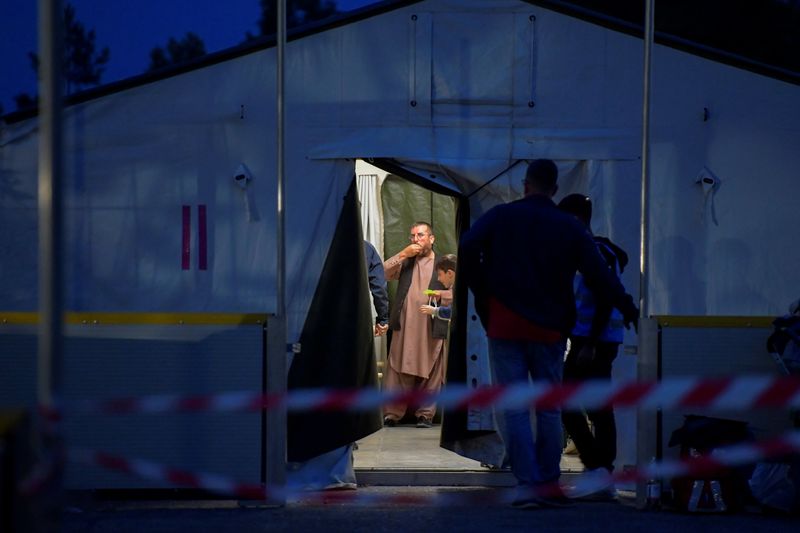 &copy; Reuters. Pessoas que foram retiradas do Afeganistão se alimetam em acampamento em Doberlug-Kirchhain, na Alemanha
20/08/2021 REUTERS/Matthias Rietschel