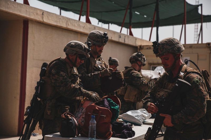&copy; Reuters. جنود من مشاة البحرية الأمريكية يفتشون الأمتعة أثناء عمليات الإجلاء في مطار حامد كرزاي في العاصمة الأفغانية كابول يوم 18 أغسطس آب 2021.
(صورة لر
