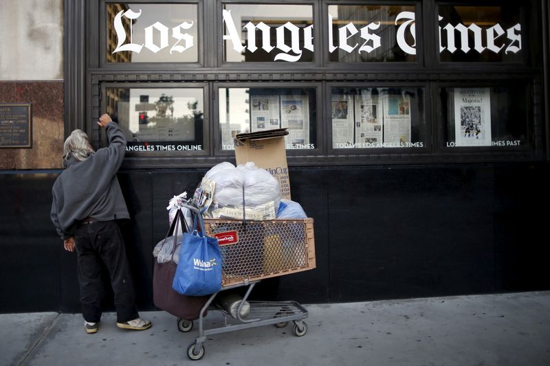 &copy; Reuters. FILE PHOTO: A homeless man reads the Los Angeles Times in the window of the building of Los Angeles Times newspaper, which is owned by Tribune Publishing Co, in Los Angeles, California, U.S., April 27, 2016. REUTERS/Lucy Nicholson 