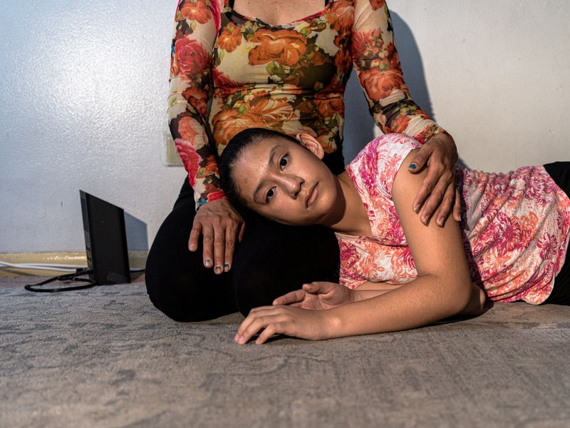 © Reuters. María, la esposa del inmigrante mexicano Eberardo, y una hija posan para una fotografía en el interior de su casa en el Medio Oeste estadounidense. 25 de julio de 2021. REUTERS/Sebastián Hidalgo