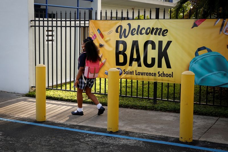 &copy; Reuters. FILE PHOTO: A student wearing a protective masks, walks past a “Welcome back” banner on the first day of school, amid the coronavirus disease (COVID-19) pandemic, at St. Lawrence Catholic School in North Miami Beach, Florida, U.S. August 18, 2021. REU