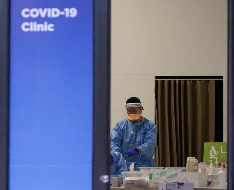 &copy; Reuters. FILE PHOTO: A medical professional works at a COVID-19 clinic during a lockdown to curb a coronavirus disease outbreak in Sydney, Australia, August 20, 2021.  REUTERS/Loren Elliott