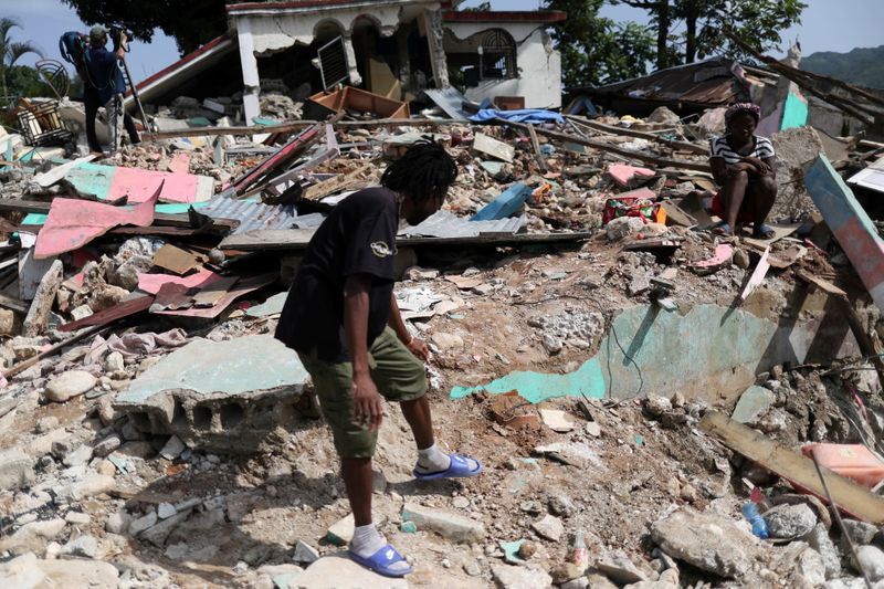 © Reuters. A resident searches through the rubble of destroyed houses, after the earthquake that took place on August 14th, in Marceline, near Les Cayes, Haiti August 20, 2021. REUTERS/Henry Romero