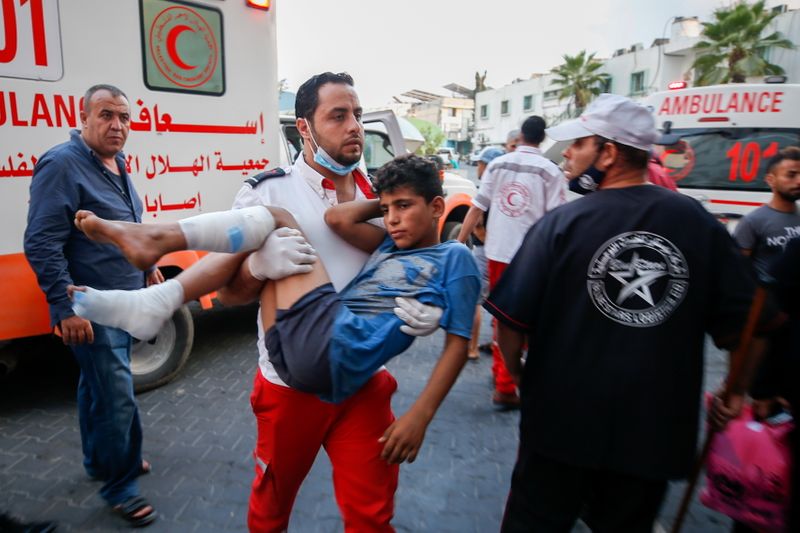 © Reuters. مسعف يحمل صبيا فلسطينيا مصابا في مدينة غزة يوم السبت بعدمشاركته في احتجاجات على الحدود بين غزة واسرائيل. تصوير: محمد سالم-رويترز.